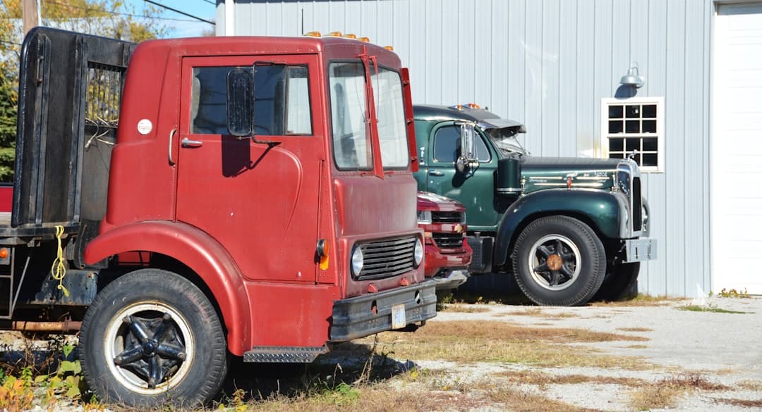 Two old trucks parked outside a building